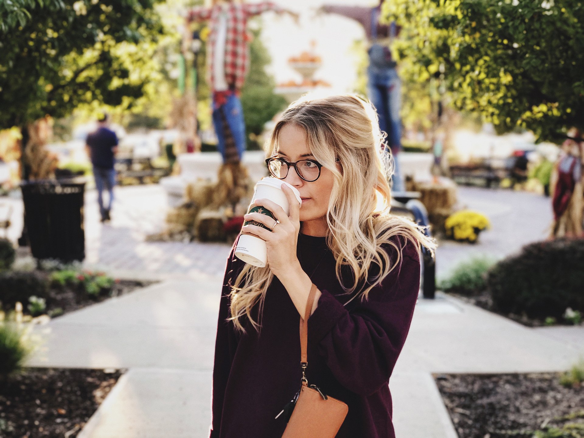 Una mujer est&aacute; bebiendo una taza de caf&eacute; en un parque.